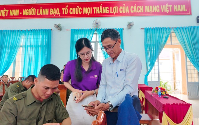 Nhân viên Công ty cổ phần công nghệ VN168 hướng dẫn người dân và cán bộ địa phương sử dụng các ứng dụng công nghệ